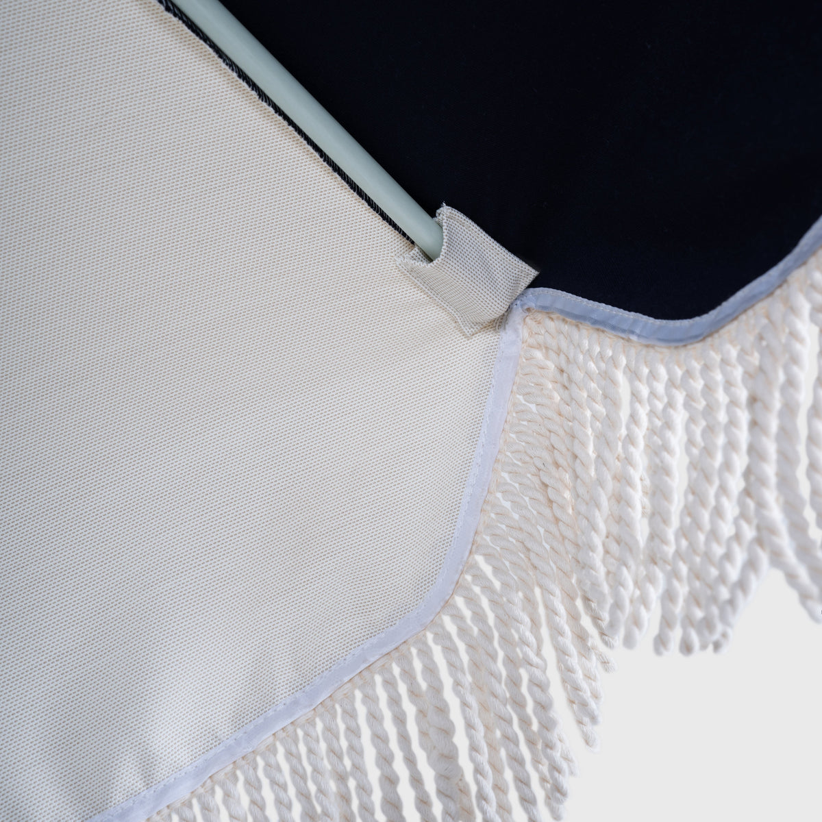 Underside of the Mentari Market Umbrella in Dark Navy, showing the rib tip and fringe