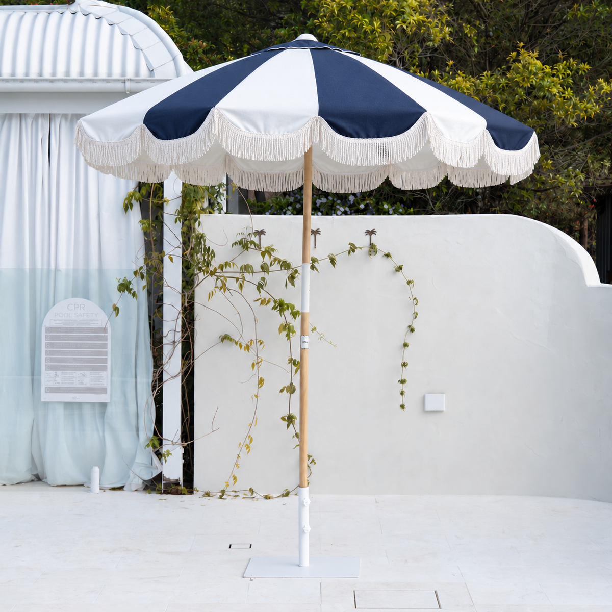Mentari Market Umbrella in Dark Navy and oat by the pool