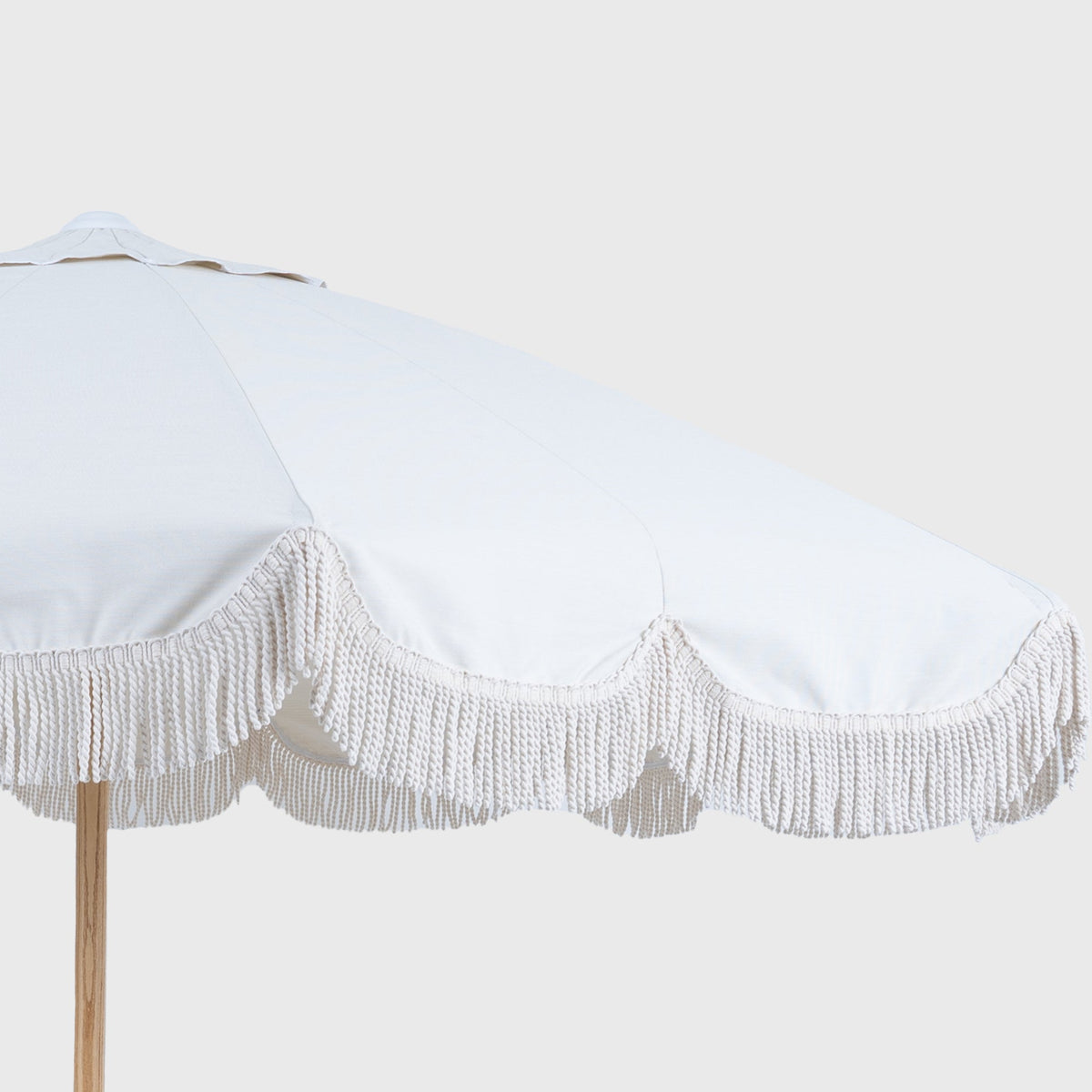 Solid Oat Mentari canopy with white fringe, angled close-up
