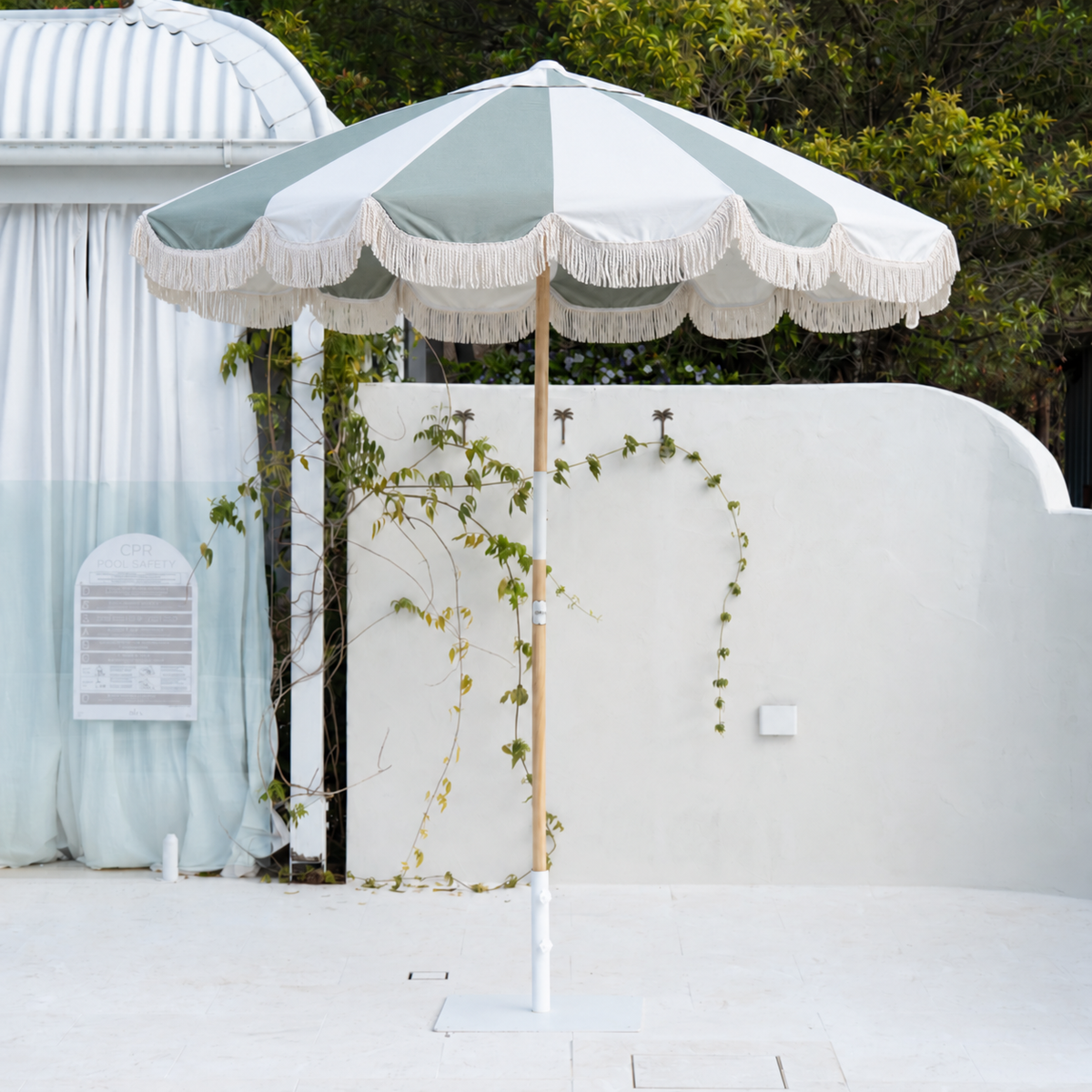 Mentari Market Umbrella in Sage and oat by the pool