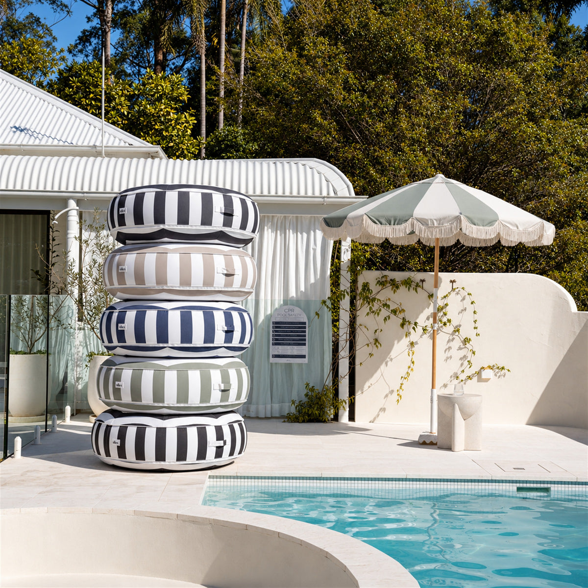 Stack of Halo Float V2 pool floats in navy, charcoal, beige, black and sage stripes